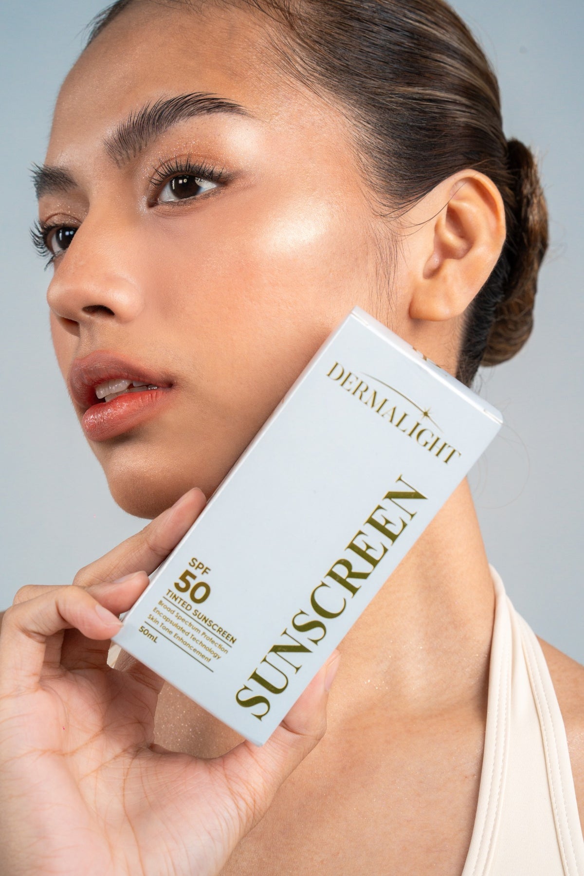 Woman with healthy glowing skin touching her cheek
